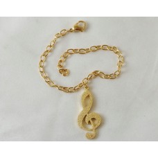 Gold-colored steel bracelet. G clef with bright satin finish
